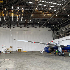 Precision dust control screen for hangar door replacement at Heathrow airport Precision dust control screen for hangar door replacement at Heathrow airport